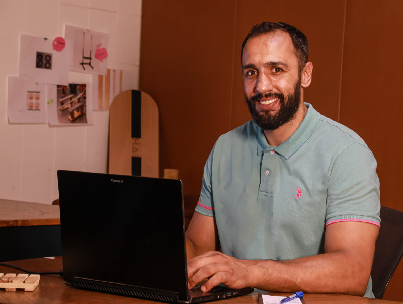 Ali Haidar, founder and product designer of HAI, smiling at his desk in the HAI design studio